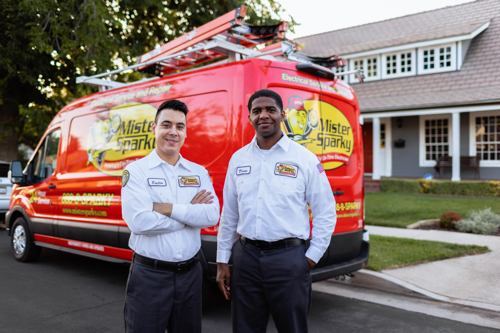 Fort Myers, FL Commercial Electrician technicians standing in front of red service van.