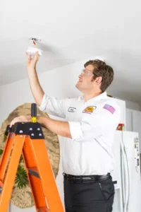 Mister Sparky Electrician Tech, Pete, Installing a smoke detector in a home in Fort Myers FL