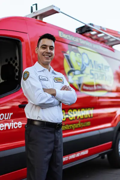 Electrical Repairs Fort Myers, FL technician standing and smiling in front of a red Mister Sparky service van.