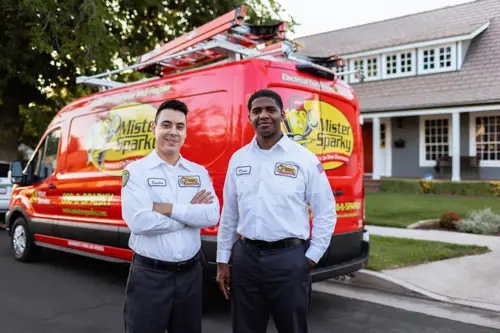 Fort Myers, FL Commercial Electrician technicians standing in front of red Mister Sparky service van.